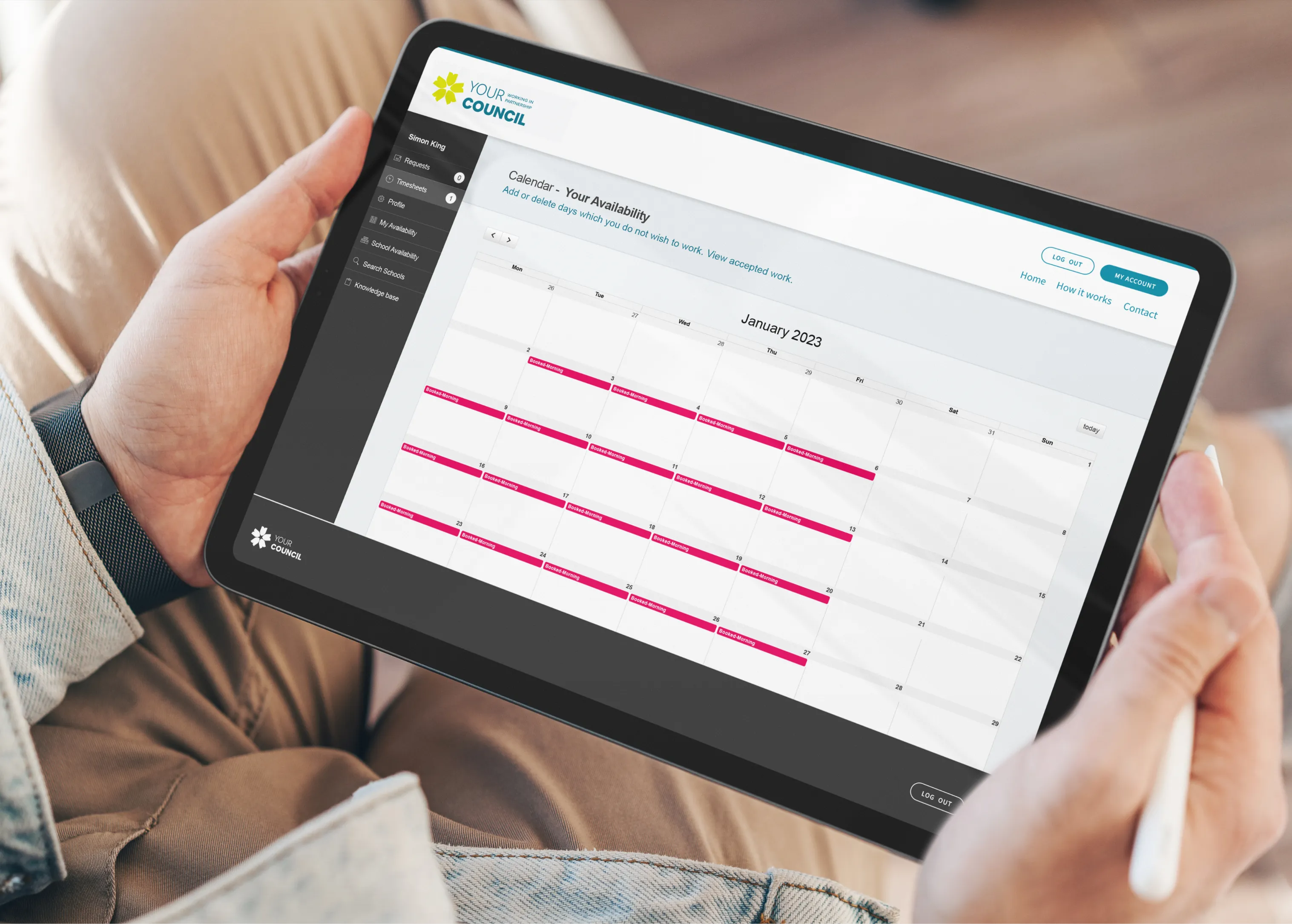 A person holding a tablet displaying the Your Council Supply Service availability calendar for January 2023, part of the supply staff booking platform built by DotPerformance for Kirklees Council